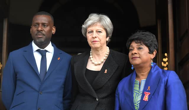 Theresa May standing with Stephen Lawrence’s brother Stuart and mother Doreen at the 25th anniversary of his death (Photo: VICTORIA JONES/AFP via Getty Images))