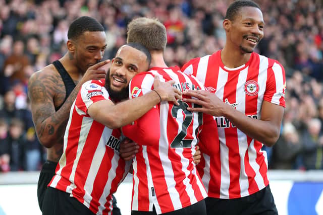 Cristian Eriksen of Brentford is embraced by team mates Ivan Toney, Bryan Mbeumo and Ethan Pinnock  (Photo by Catherine Ivill/Getty Images)