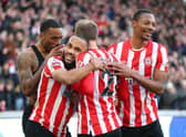 Cristian Eriksen of Brentford is embraced by team mates Ivan Toney, Bryan Mbeumo and Ethan Pinnock  (Photo by Catherine Ivill/Getty Images)