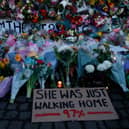 A sign saying “SHE WAS JUST WALKING HOME 97%” among the flowers and candles on Clapham Common where floral tributes have been placed for Sarah Everard on March 13, 2021 in London, England (Photo by Hollie Adams/Getty Images)