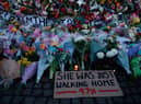 A sign saying “SHE WAS JUST WALKING HOME 97%” among the flowers and candles on Clapham Common where floral tributes have been placed for Sarah Everard on March 13, 2021 in London, England (Photo by Hollie Adams/Getty Images)