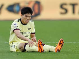 Takehiro Tomiyasu reacts on the pitch after being tackled during the English Premier League football match (Photo by IAN KINGTON/IKIMAGES/AFP via Getty Images)