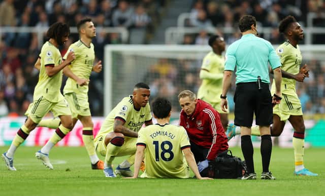 Takehiro Tomiyasu of Arsenal receives medical treatment during the Premier League match  (Photo by Ian MacNicol/Getty Images)