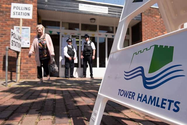 Police officers stand outside a polling station in Tower Hamlets in 2015 - the elections over which Lutfur Rahman was convicted of electoral fraud and removed from office. Credit: LEON NEAL/AFP via Getty Images
