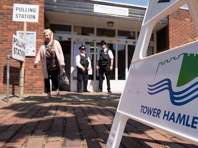 Police officers stand outside a polling station in Tower Hamlets in 2015 - the elections over which Lutfur Rahman was convicted of electoral fraud and removed from office. Credit: LEON NEAL/AFP via Getty Images