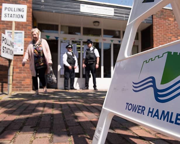 Police officers stand outside a polling station in Tower Hamlets in 2015 - the elections over which Lutfur Rahman was convicted of electoral fraud and removed from office. Credit: LEON NEAL/AFP via Getty Images