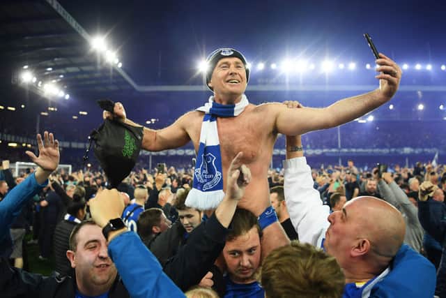 Everton fans celebrate on the pitch following their sides victory as they avoid relegation after the Premier League match between Everton and Crystal Palace at Goodison Park. Credit: Michael Regan/Getty Images