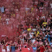 Brentford fans celebrate during the English Premier League football match (Photo by ADRIAN DENNIS/AFP via Getty Images)