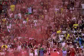 Brentford fans celebrate during the English Premier League football match (Photo by ADRIAN DENNIS/AFP via Getty Images)