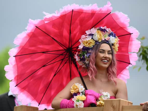 A visitor in a flower themed dress reacts as they attend the 2022 RHS Chelsea Flower Show in London. (Photo: Getty)