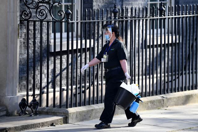 A cleaner in PPE outside Downing Street. Photo: Getty