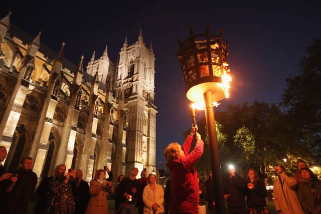 Reverand Jane Hedges, Canon of Westminster Abbey, lights a beacon outside the Abbey as part of Diamond Jubilee celebrations on June 4, 2012 in London, England