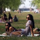 People enjoy the warm weather in Green Park, London (Photo by ISABEL INFANTES/AFP via Getty Images)