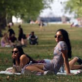 People enjoy the warm weather in Green Park, London (Photo by ISABEL INFANTES/AFP via Getty Images)