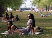 People enjoy the warm weather in Green Park, London (Photo by ISABEL INFANTES/AFP via Getty Images)