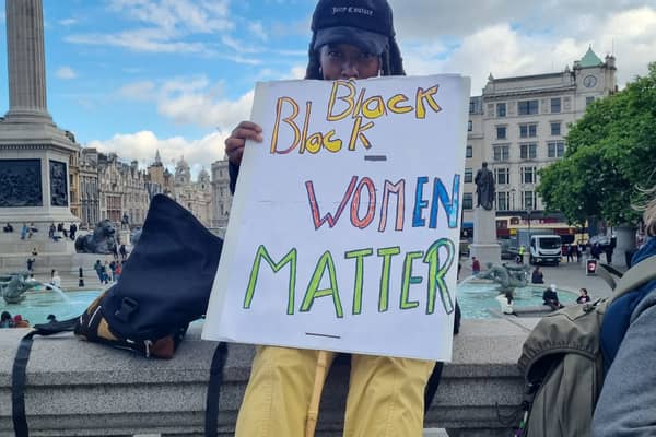 Protestor holding a Black Women Matter sign.