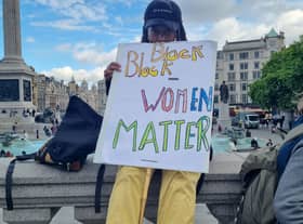 Protestor holding a Black Women Matter sign.