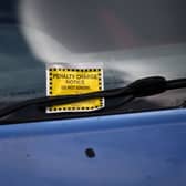 A Penalty Charge Notice (PCN) or parking ticket is pictured attached to the windscreen of a van in south London. Credit: DANIEL LEAL/AFP via Getty Images
