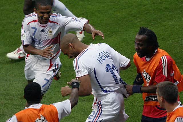 French defender Pascal Chimbonda (R) pulls on the jersey of French forward Thierry Henry (C) to celebrate after Henry scored against Brazil at the 2006 World Cup. Credit: JOHN MACDOUGALL/AFP via Getty Images