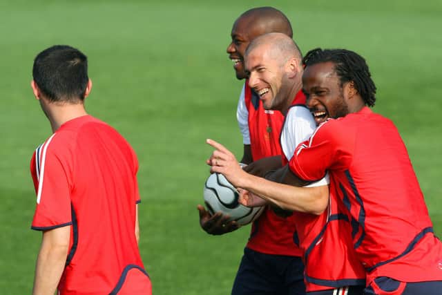 French midfielder Zinedine Zidane shares a laugh with Pascal Chimbonda (R) during a training session on the eve of the World Cup 2006 final Italy vs. France. Credit: JOHN MACDOUGALL/AFP via Getty Images