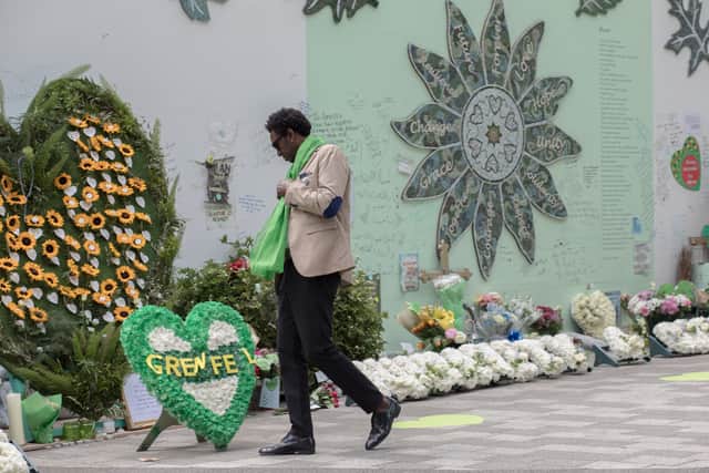 A mourner walks by the Grenfell memorial display. Photo: Getty