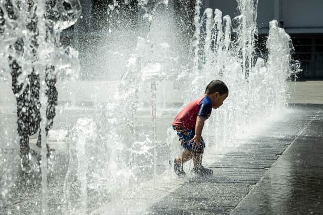 Children cool off in the fountains in Wembley Arena. Credit: Chris Winter