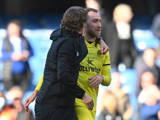Danish midfielder Christian Eriksen (R) is congratulated by Brentford’s Danish head coach Thomas Frank (Photo by GLYN KIRK/AFP via Getty Images)