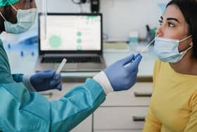 A doctor performing a nasal swab test on a patient in a medical clinic for a possible coronavirus infection. Photo: Adobe Stock