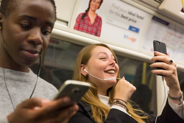 Commuters using their phones in a tunnel on the Jubilee line