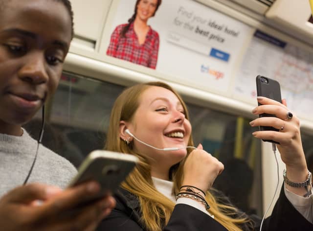 Commuters using their phones in a tunnel on the Jubilee line