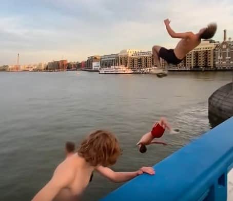 Four young men can be seen jumping from Tower Bridge into the River Thames. Photo: Adam Szaniawski