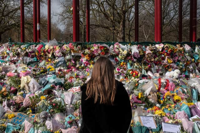 A woman places floral tributes at the bandstand in Clapham Common to Sarah Everard. Credit: Dan Kitwood/Getty Images