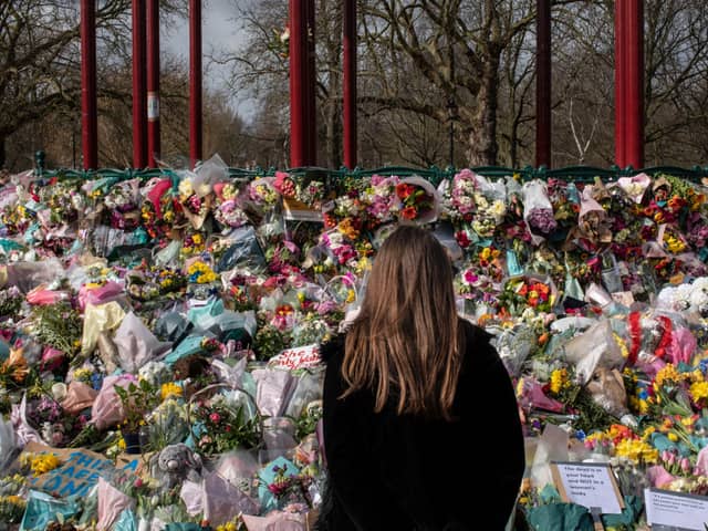 A woman places floral tributes at the bandstand in Clapham Common to Sarah Everard. Credit: Dan Kitwood/Getty Images