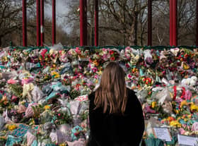 A woman places floral tributes at the bandstand in Clapham Common to Sarah Everard. Credit: Dan Kitwood/Getty Images