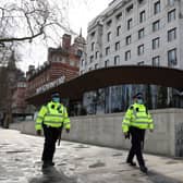 Police walk in front of New Scotland Yard. Credit: ADRIAN DENNIS/AFP via Getty Images