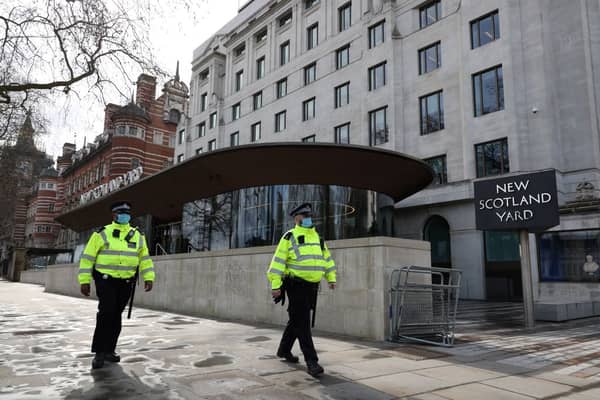 Police walk in front of New Scotland Yard. Credit: ADRIAN DENNIS/AFP via Getty Images