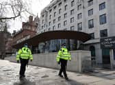 Police walk in front of New Scotland Yard. Credit: ADRIAN DENNIS/AFP via Getty Images