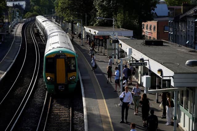 Commuters wait for their train on a platform at West Norwood station in south London on July 18, 2022 amid disruption warnings over extreme heat. Credit: NIKLAS HALLE’N/AFP via Getty Images