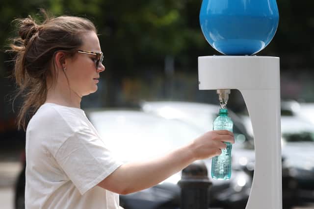A woman refills a water bottle at Victoria Park on July 17, 2022 in London, as city dwellers found ways to stay cool. Photo: Getty