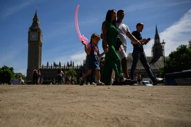 Tourists walk on the sun-baked Parliament Square on July 14, 2022 in London. Photo: Getty