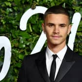 Former Arsenal player, Romeo Beckham poses on the red carpet upon arrival at The Fashion Awards 2021 in London .