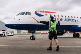 An Aircraft Turnaround Lead directs a British Airways plane on the runway at London City Airport