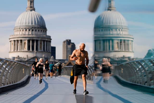 Pesestrians walk along The Millennium Bridge away from St Paul's Cathedral in London