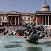 People cool off beside the fountains in Trafalgar Square in central London on June 17, 2022