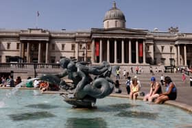 People cool off beside the fountains in Trafalgar Square in central London on June 17, 2022