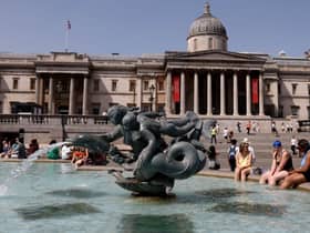 People cool off beside the fountains in Trafalgar Square in central London on June 17, 2022