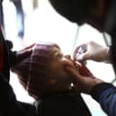 A Syrian child receives a vaccination against polio during a campaign organised by the Syrian Arab Red Crescent