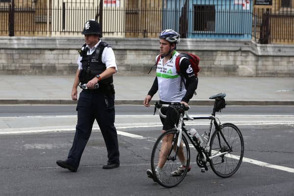 A police officer escorts a cyclist in central London. Photo: AFP via Getty Images