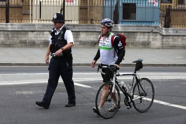 A police officer escorts a cyclist in central London. Photo: AFP via Getty Images
