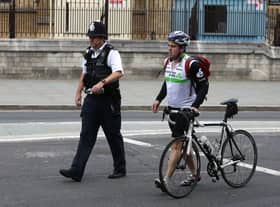 A police officer escorts a cyclist in central London. Photo: AFP via Getty Images